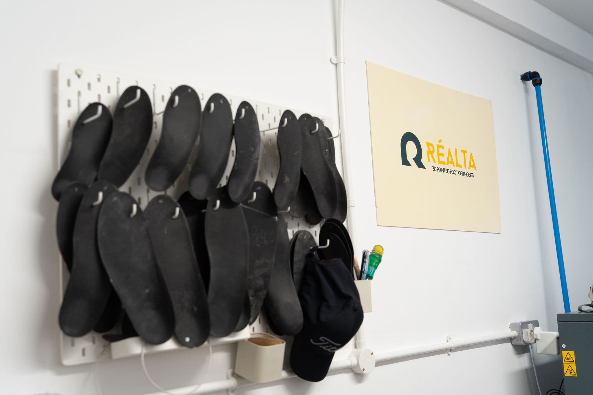 Réalta Labs workshop pegboard wall with branded sign