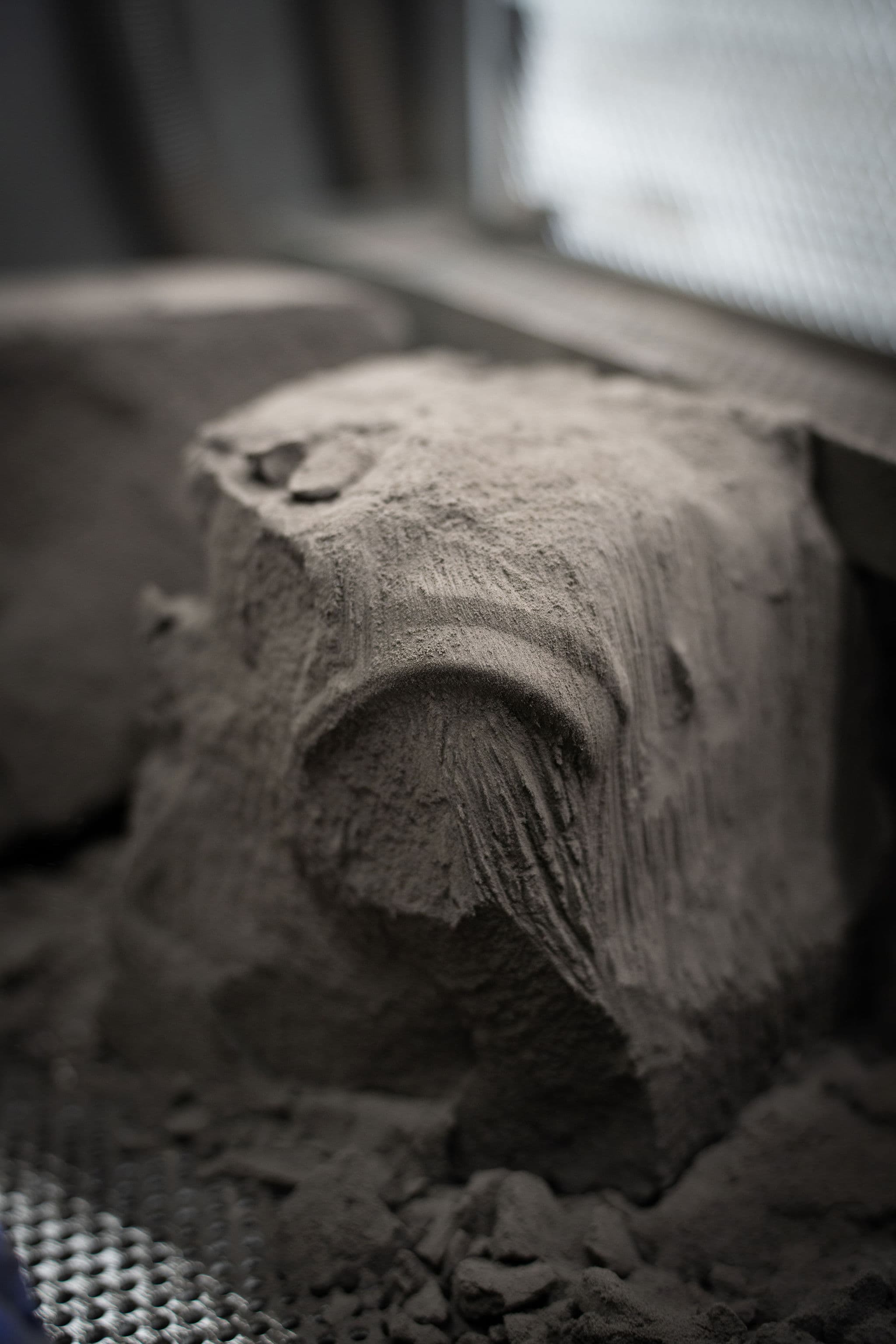 Freshly printed orthotic shells emerging from nylon powder