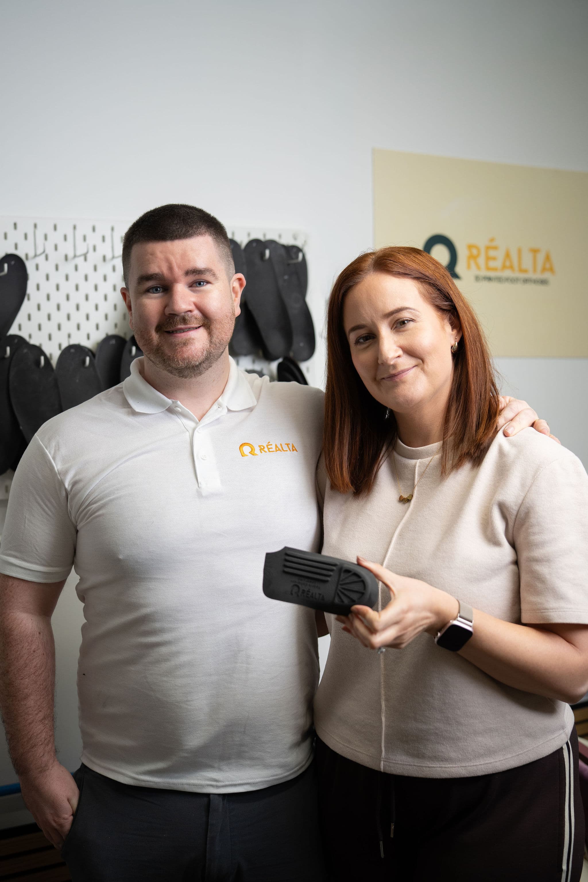 Paul and Sharon McMullan together holding a custom orthotic